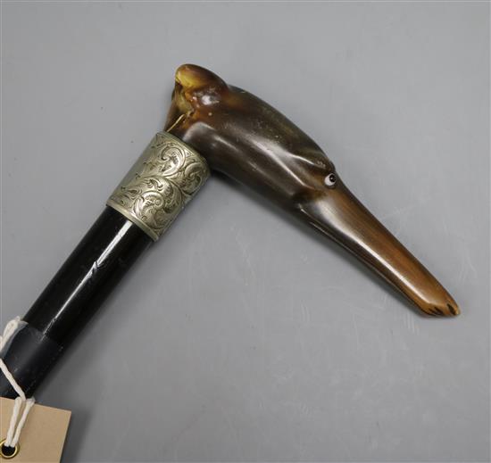 A ebonised walking cane with engraved white metal collar and carved horn greyhound handle length 86cm
